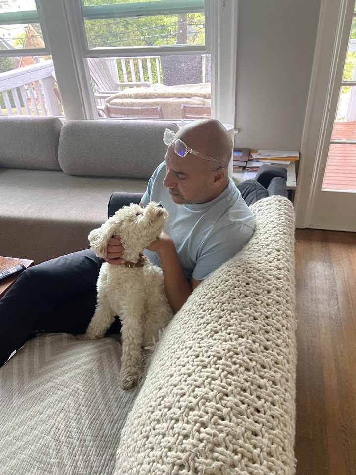Rachid relaxing with white fluffy dog
